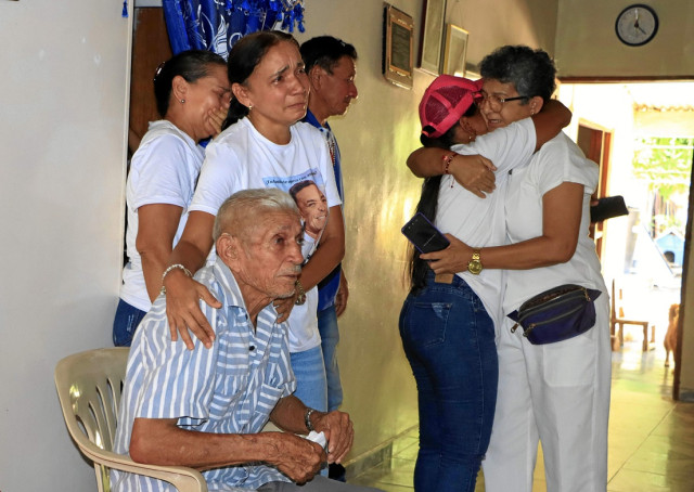 Jacob Díaz Brito, padre de Luis Manuel Díaz, junto a familiares y amigos, observa por televisión la liberación de su hijo.