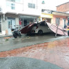 Un vehículo particular blanco quedó atrapado bajo unas láminas metálicas tras el vendaval.