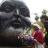 El alcalde de Medellín, Daniel Quintero, coloca ofrendas florales en la escultura "Cabeza" del maestro Fernando Botero durante un homenaje tras su fallecimiento, en la Plaza Botero en Medellín. 