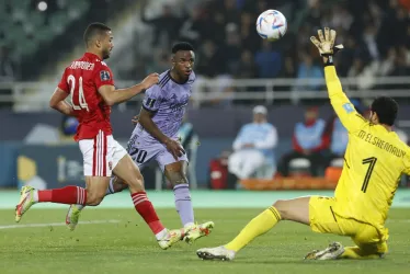 El delantero brasileño del Real Madrid Vinícius Jr (c) remata ante el guardameta del Al Ahly, el egipcio Mohamed El Shenawy (d), para conseguir el primer gol del equipo madridista durante el partido correspondiente a las semifinales del Mundial de Clubes entre el Al Ahly y el Real Madrid, este miércoles en Rabat.