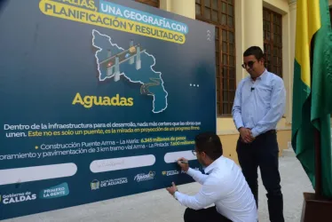 El secretario de Planeación, Carlos Ánderson García Guerrero, firma. A su lado, el alcalde de Aguadas, Juan Carlos Ramírez.