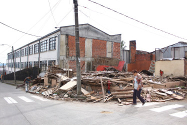 Parte de la vivienda esquinera del barrio San José de Manizales, con amenaza de ruina, se fue al suelo el pasado viernes. Según la comunidad, el desplome fue ocasionado por el saqueo de habitantes de calle. La casa está ubicada al lado del Instituto Manizales y es responsabilidad de la Alcaldía. A la izquierda un habitante de calle recolecta madera de la estructura y a la derecha una residente del barrio atraviesa la zona por la calle, ya que los escombros taparon el andén.