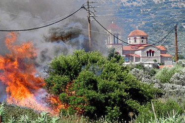 Los arbustos y los árboles arden durante un incendio forestal en la aldea de Metochi, cerca de Epidauro, Grecia. Hay alerta alta de riesgo extremo, de categoría 5 para cinco regiones griegas de Ática, Grecia central, el Peloponeso, Grecia occidental y el sur del Egeo con la isla de Rodas, según el Mapa de de riesgo de incendios de la Secretaría General de Protección Civil.