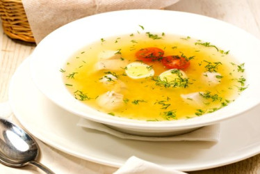 Caldo de huevo con una cuchara al lado.