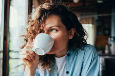 Mujer bebiendo algo de una taza