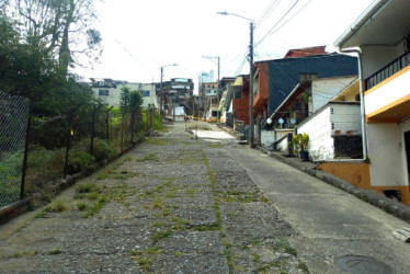 La calle 11 tiene grietas en donde la maleza crece en las aberturas