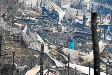 Foto | EFE | LA PATRIA  Los habitantes del sector ayer en la mañana buscaban entre las cenizas algo para rescatar de sus casas.