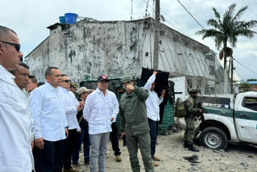 Gustavo Petro (c) y el director de la policía William René Salamanca (d) observando este jueves os daños a la estación de policía que fue hostigada por disidentes de las Farc. 