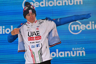 El ciclista esloveno Tadej Pogacar del UAE Team Emirates, aparte del rosa del líder general, también conserva el maillot azul de mejor escalador, celebra en el podio tras la 16ª etapa del Giro de Italia 2024.