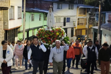 El resplandor del amanecer ilumina el paso de los feligreses y de los religiosos que cada mes asignan un sector determinado, como el de la foto que corresponde a Granjas y Viviendas.