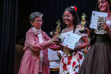 María José Henao Salazar recibe de Aracely Aristizábal el trofeo que la acredita como ganadora del Festival de la Canción Colombiana.