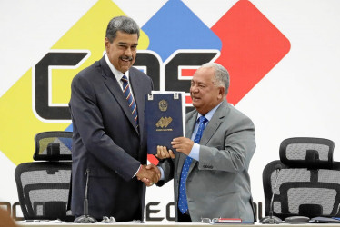 El mandatario de Venezuela, Nicolás Maduro, y el presidente de Consejo Nacional Electoral, Elvis Amoroso, sostienen el acta de juramentación del presidente electo, en Caracas (Venezuela).