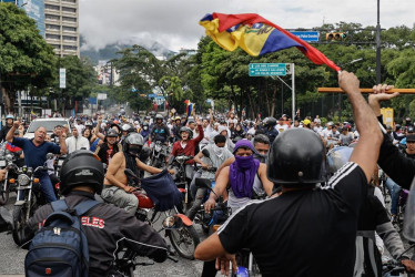 Personas recorren las calles en motocicletas durante una protesta por los resultados de las elecciones presidenciales este lunes, en Caracas (Venezuela). 