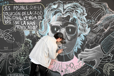 El artista Sergio Antonio Palacio Montoya dibuja un mural con el rostro del periodista y humorista asesinado Jaime Garzón, durante el acto conmemorativo en Bogotá.