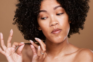 Mujer mirando las puntas de su cabello